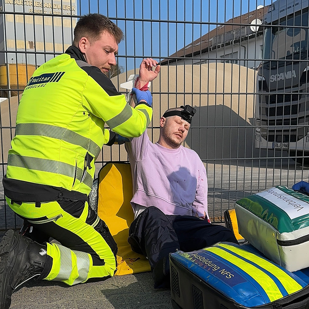 Einsatzkraft der Veritas Ambulanz versorgt bei einer Übung die Armverletzung eines Patienten